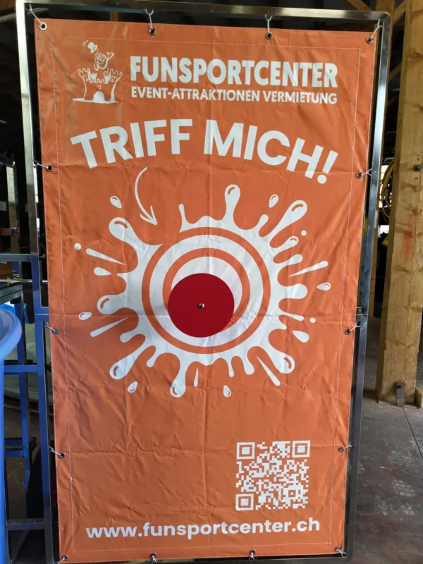 Dunk Tank Orangefarbenes Triff-mich-Banner mit roter Zielscheibe des Dunk Tank von Funsportcenter Tanner, Auslöser für den Sturz ins Wasser